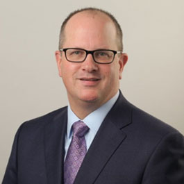 man with black jacket and silver tie