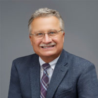 grey hair man with eyeglasses wearing suite and tie